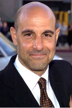 a bald man wearing a suit and tie