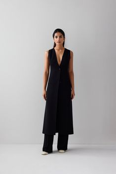 A touch of sophistication to your wardrobe with our idée long vest. Made from high-quality puerto rico fabric and lined for ultimate comfort, this contemporary vest features two buttons, two side pockets, and a single back vent. The versatile design and casual aesthetic make it perfect for everyday wear, while the sleek fit and formal aesthetic make it suitable for any formal occasion. You can even wear it outdoors for an added touch of style. The blend of polyester and viscose ensures you stay Business Vest With Single Button Sleeveless, Business Vest With Single Button, Business Sleeveless Vest With Single Button, Business Vest With Hidden Button Closure, Sleeveless Business Vest With Hidden Button Closure, Sleeveless Business Casual Blazer With Button Closure, Sleeveless Business Outerwear With Button Closure, Elegant Vest For Layering, Chic Tailored Vest Outerwear