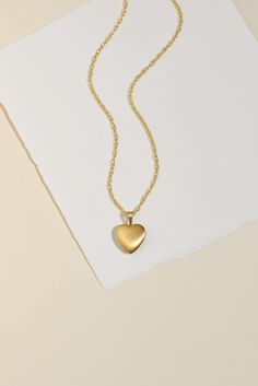 Experience the timeless beauty of our Heart Locket Necklace. Keep your loved ones close to your heart with this heirloom piece that holds precious memories. With a unique double-sided finish, choose between shiny gold or brushed matte. Strung on a sparkly double rope chain, this necklace makes a meaningful gift for Mother's Day or any special occasion. Size: Heart locket measures 18 x 12 mm Locket features a beautiful double sided finish - one side is shiny and the other is matte. You can remove 14k Gold Heart Pendant Keepsake Jewelry, Elegant Brass Jewelry With Heart Charm, Minimalist Gold Jewelry With Heart Charm, Gold Minimalist Jewelry With Heart Charm, Gold Heart Necklace In Sterling Silver, Classic Tarnish Resistant Heart Pendant Necklace, Classic Tarnish-resistant Heart Pendant Necklace, Timeless Heart Pendant Jewelry Gift, Gold-tone Heart-shaped Jewelry With Adjustable Chain