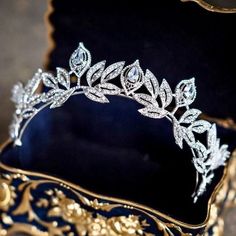 a tiara is sitting in a gold and black box