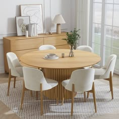 a round wooden table surrounded by white chairs