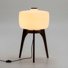 a table lamp with a white light on it and a black cord plugged into the base