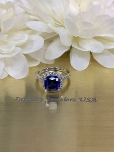 Cushion cut ceylon blue sapphire engagement ring, with natural round diamond accents 14k white gold # 5891 #DiamondRing #CeylonBlue #WeddingRing #SapphireRing #AnniversaryGift #BlueSapphire #EngagementRing #WhiteGold #HolidayGift #DiamondHalo Blue Princess Cut Jewelry With Diamond Accents, Tanzanite Asscher Cut Ring With Prong Setting, Cushion Cut Sapphire Ring With Cubic Zirconia Accent Stones, Blue Bridal Jewelry With Diamond Accents In Cubic Zirconia, Cushion Cut Diamond Ring With Center Stone Lab-created Sapphire, Lab-created Sapphire Diamond Ring With Cushion Cut, Sapphire Birthstone Ring With Diamond Center Stone, Tanzanite Diamond Ring Gia Certified For Anniversary, Tanzanite Sapphire Ring With Prong Setting