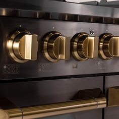 an oven with gold knobs and brass handles