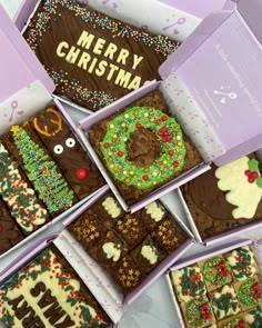 six decorated christmas brownies in boxes sitting on a table with the words merry christmas written on them