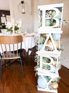 the letters are decorated with flowers and baubles for a baby's first birthday party