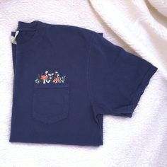 Welcome to our shop! Our Nature-Inspired Mushroom & Wildflowers Embroidered Pocket Tee combines comfort, style, and a love for nature. Here's why you'll love it: ✨ Product Details: Material: Made from 100% cotton, ensuring a soft, breathable, and comfortable feel. Design: Features a beautifully detailed embroidery of nature-inspired mushrooms surrounded by wildflowers above the pocket, adding a touch of nature to your wardrobe. Sizes: Available in sizes S-2XL to fit a variety of body types. Colo Green Orchid, Cottagecore Shirt, Embroidered Pocket, Detailed Embroidery, Intricate Embroidery, Grey Light, Great Conversation Starters, Unique Features, Midnight Black