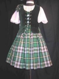 a green and white plaid dress with black vest on a mannequin headdress