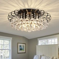 a bed room with a neatly made bed and a chandelier hanging from the ceiling