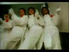 four women dressed in white are posing for the camera