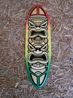 a colorful surfboard sitting on top of dry grass