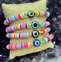 "🌈This listing is for One Rainbow Evil Eye Handmade Heishi Beaded Bracelet. These bracelets fit wrist sizes on average 7-8\".  🧿The evil eye is a symbol of spiritual protection. Dating back thousands of years and seen in many different cultures, the evil eye is known to ward off negativity by sending it back to the person who sent it.  The Evil Eye Charm on this bracelet is available in 2 colors:  Blue or Black  **Due to the unique nature of each stone, your item may vary slightly from the picture shown. All items are cleansed with white sage before being shipped. Any comments, questions, or concerns feel free to contact me, I am here to help!" Handmade Multicolor Beaded Bracelets For Jewelry Making, Multicolor Friendship Bracelets With Spacer Beads For Beach, Colorful Beaded Bracelets With Spacer Beads As Gift, Multicolor Round Beads Stretch Bracelet Gift, Multicolor Round Beads Stretch Bracelet As Gift, Multicolor Stretch Bracelet With Round Beads As Gift, Colorful Beaded Bracelets For Beach, Multicolor Round Beaded Bracelet Gift, Colorful Heishi Beaded Bracelets For Festivals