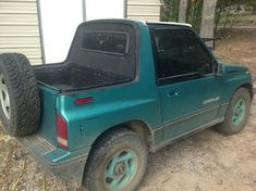 a green pick up truck parked in front of a house