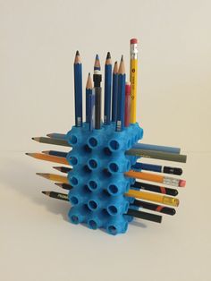 there are many pencils in the holder on the table, and one is blue