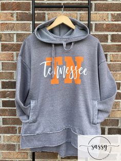 Tennessee Sweatshirt  TN Sweatshirt   Tennessee Shirt Hoodie is a very soft, vintage washed crew neck hoodie fleece with a squared off hem and deep side slits.  Hoodie also has 2 pockets. This hoodie runs true to size. Hoodie is vintage gray with tennessee orange and white design.   The shirt is 52% polyester and 48% cotton.   All shirts are made to order and ship within a 2-3 days.  If you need a shirt sooner, please let me know and I will try my best to accommodate your request. Tn Sweatshirt, Tennessee Sweatshirt, Tennessee Shirt, Tennessee Orange, Knoxville Tn, Neck Hoodie, White Design, Tennessee, Clothing Items