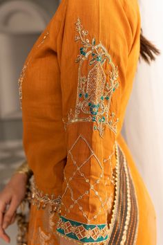 Mustard Orange Embroidered Pakistani Long Pishwa Dupatta Party Dress a pure festive look is introduced in this mustard orange drapery exuding heavenly embellished mughal inspired and ornamental patterns, festooned with rich, glorious details. Silk Pishwas: This Mustard Silk Pishwas comes with a beautiful frock in premium quality raw silk. This frock is decorated with breathtaking embroidered patterns accompanied by a tilla. Furthermore, the stunning cutwork on the hemline adds to the grace of th Mughal Inspired Fashion, Organza Styles, Beautiful Frocks, Kurti Sleeves Design, Mustard Orange, Pakistani Designer Clothes, Organza Shirt, Punjabi Dress, Dress Design Patterns