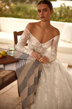 a woman in a wedding dress sitting at a table