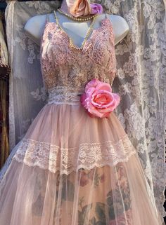 a mannequin wearing a pink dress with flowers on it's waist and neck