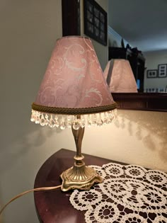 a lamp that is sitting on top of a table with a doily underneath it