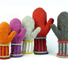 five different colored mittens are lined up in the shape of gloves, one with a striped design on it