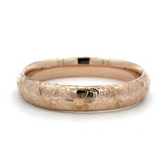 This estate bangle bracelet is crafted in 10Kt yellow gold and features an engraved design. The bracelet is wide and makes a statement on its own or stacked with other bracelets. A beautiful and unique addition to any jewelry collection. Elegant Etched Bangle For Wedding, Engraved 14k Gold Round Bracelets, Classic Etched Bangle Bracelet, Classic Etched Bangle Bracelets, Heirloom 14k Gold Engraved Bangle, Elegant Etched Wedding Bracelets, Elegant Etched Bracelets For Wedding, 14k Gold Engraved Bangle Bracelet, Elegant Etched Cuff Bracelet For Anniversary