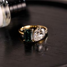 two engagement rings sitting on top of a table next to an empty bottle and pill bottle