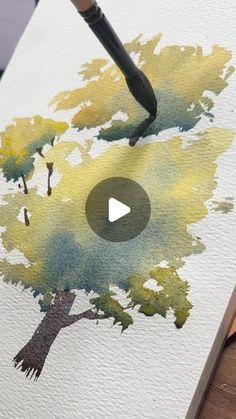 someone is painting a tree with watercolors