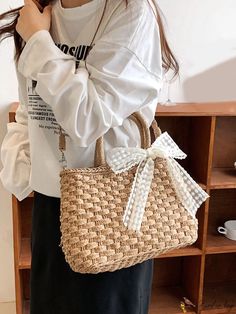 a woman wearing a white shirt and holding a straw bag