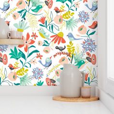 the wallpaper in this kitchen is colorful and has birds, flowers, and leaves on it