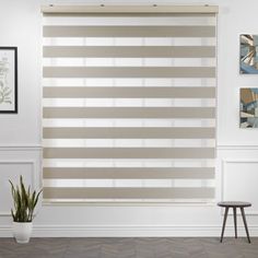 a living room scene with focus on the blinds in the window and the chair against the wall