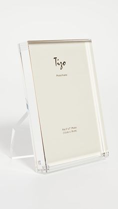 an empty glass frame with the word type printed in black ink on it, sitting on a white surface