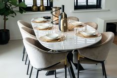 a dining room table set with place settings