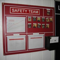 a red safety team board mounted to the side of a wall