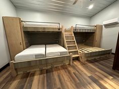 two bunk beds in a room with wooden floors