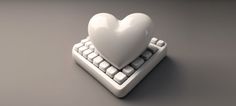 a computer keyboard with a white heart on it's key board, sitting on a gray surface