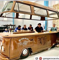 a group of men sitting at a table in front of a food truck that is painted brown