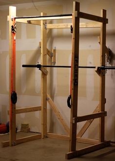 the gym equipment is being constructed in an unfinished room with white walls and wooden beams