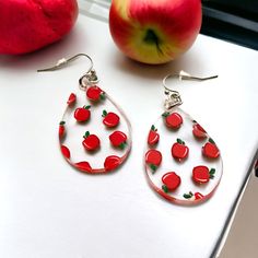 Introducing our charming  red apple dangle earrings - the perfect gift to show your appreciation to a special teacher in your life. These earrings feature a playful design of red apples UV printed on clear acrylic, creating a stunning and eye-catching effect. Laser cut to the shape of a teardrop. Crafted with care and high quality materials, these earrings are laser cut to shape into a dangle drop style that is both elegant and fun. The clear acrylic material makes them lightweight and comfortab Cherry Colored Earrings For Valentine's Day Gift, Cherry Color Earrings For Valentine's Day Gift, Cherry Earrings For Valentine's Day Gift, Personalized Red Drop Earrings, Personalized Red Dangle Earrings, Pink Hangers, Apple Jewelry, Apple Earrings, Teacher Appreciation Gift