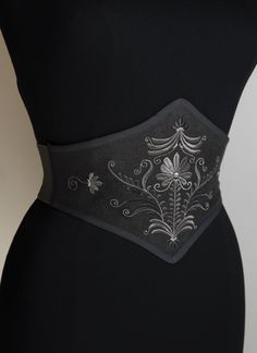 "The Hungarian Garden" Do you like corsets but also like to feel comfortable in your clothes? This belt is made for you! This is an embroidered elastic waist cincher, made of quality linen. Steel stays on the front of the belt provide support and give the illusion that it is a real corset. The robust elastic that makes up the back of this accessory allows greater sheathing than a classic belt and will adapt perfectly to your size. The embroidered pattern was created in our workshop for this uniq Luxury Embroidered Belt For Formal Occasions, Luxury Designer Corset Belt With Belt Loops, Luxury Chic Corset Belt, Luxury Elegant Spring Corset Belt, Luxury Corset Belt For Evening With Belt Loops, Luxury Corset Belt With Corset Back For Weddings, Luxury Underbust Corset Belt For Party, Elegant Luxury Adjustable Corset Belt, Luxury Evening Corset Belt With Belt Included