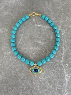 Handcrafted by IJ Design Boutique 🤍🌟 Made in Uk Made of: * Turquoise beads * Handmade painted ceramic evil eye pendant * 18k gold-filled details  * Anti-allergenic * Long lasting * Heavy  Length customized. -IJ DESIGN BOUTIQUE- From necklaces to earrings, we make jewellery using a wide range of materials. From silver and gold plated to freshwater pearls and real gemstones.  Our collections are all based on the latest trends in jewellery along with classic pieces which won't date. You are able Turquoise Evil Eye Bracelet Jewelry, Handmade Turquoise Choker Jewelry, Turquoise Evil Eye Bracelet, Turquoise Evil Eye Amulet Jewelry, Turquoise Evil Eye Amulet Necklace, Handmade Turquoise Evil Eye Bracelet With Round Beads, Bohemian Turquoise Evil Eye Necklace, Handmade Blue Turquoise Choker Necklace, Evil Eye Round Beads For Jewelry Making