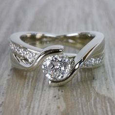 a white gold engagement ring with diamonds on the side and an elegant twisty band