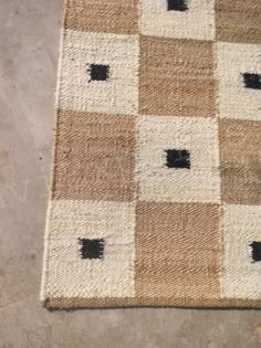 a brown and white rug with black squares on it