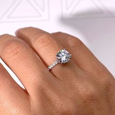 a woman's hand with a diamond ring on it