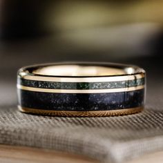 a black and gold wedding band on top of a book