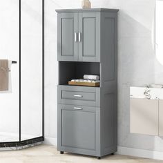 a bathroom with a gray cabinet next to a shower