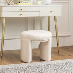 a white vanity table with a mirror and stool