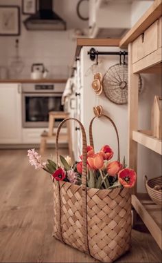 two baskets filled with flowers sitting on top of a wooden floor next to an oven