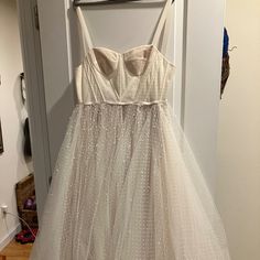 a white dress hanging up on a door