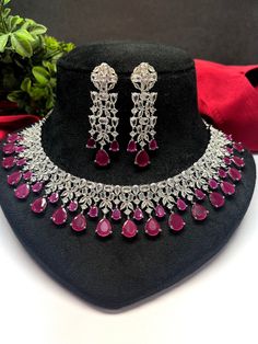 Gorgeous fine quality lab Ruby dark pink zircon and  diamonds studded necklace with white gold rhodium plating and matching Earrings Item contains: Necklace and earrings AAA quality cubic zirconia used. Highest quality and craftsmanship Necklace Fitting is adjustable Earrings Closure: Pushback Necklace Closure: chain with adjustable length Hook Details-  -Handmade item -Delivery from a small business in India -Materials: white rhodium, stones, cz, zircon, American diamond -Jewellery type: Earrin Ruby Necklaces With Sparkling Stones For Party, Ruby Jewelry With Diamond Accents For Party, Party Ruby Necklaces With Sparkling Stones, Dazzling Ruby Necklace With Sparkling Stones, Party Ruby Necklace With Sparkling Stones, Diamond Dangle Jewelry For Celebration, Fine Jewelry Sets With Cubic Zirconia For Celebration, Hand Set Diamond Dangle Jewelry, Fine Jewelry Sets For Celebration With Cubic Zirconia