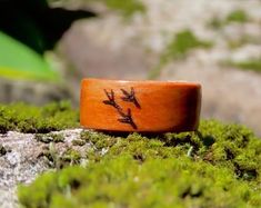 a wooden ring sitting on top of moss covered rocks